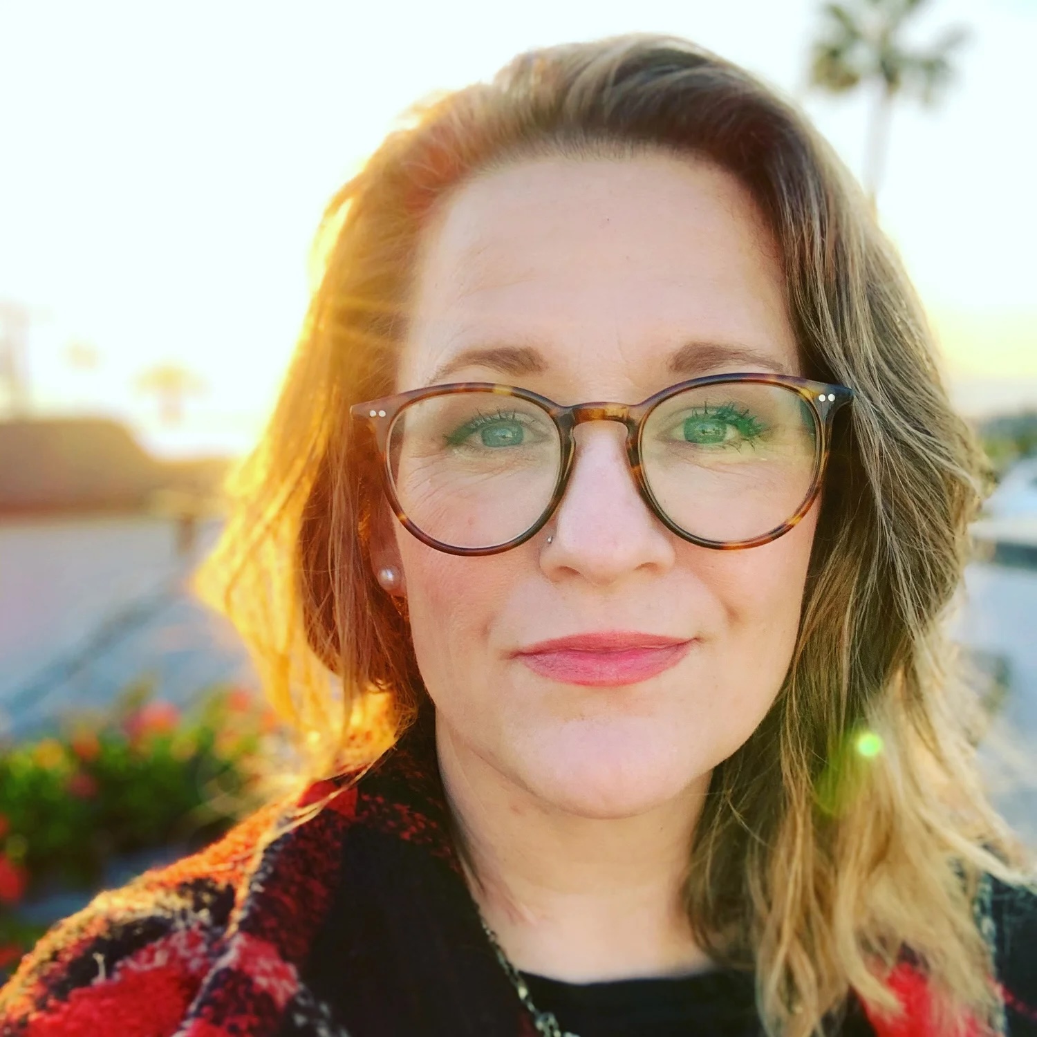 Ashley Hales, backlit by the sun, wearing tortoiseshell glasses